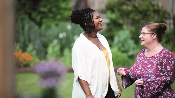 Two Women Chat In Garden