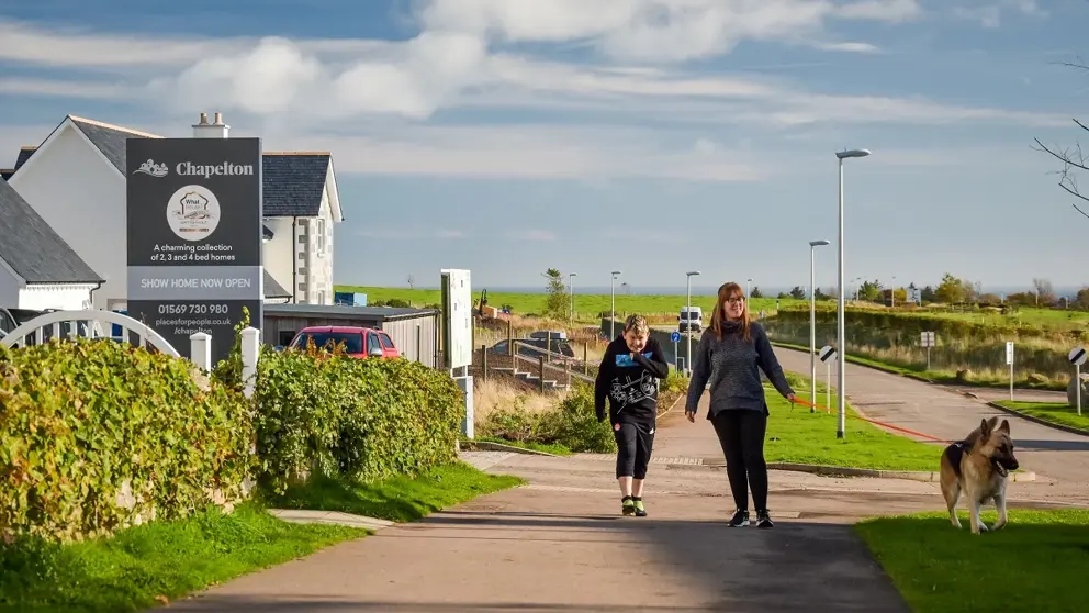 Mother And Son Walking With Dog